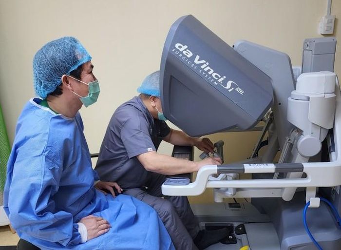 Bác sĩ Philippines đang thao tác tại bàn điều khiển hệ thống robot phẫu thuật dưới sự hướng dẫn của Bác sĩ Nguyễn Phú Hữu. (Ảnh: Bệnh viện cung cấp)